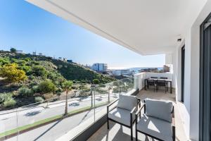a balcony with chairs and a view of a city at Middle Views West in Fuengirola