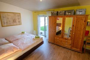 a bedroom with a large bed and a wooden cabinet at Haus Sieber in Schiltach
