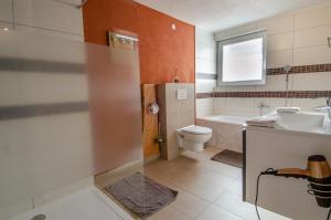 a bathroom with a toilet and a sink and a tub at Haus Sieber in Schiltach +18 photos