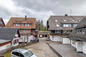 a group of buildings with a car parked in a parking lot at Ferienhaus im Grund in Hinterzarten