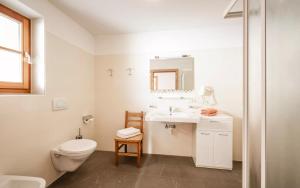 a white bathroom with a toilet and a sink at Rieplechn App in Sand in Taufers
