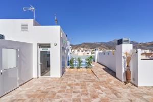 a courtyard of a white building with potted plants at Nerja Boutique 101 Deluxe in Nerja