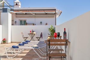 a patio with chairs and a table with wine glasses at Nerja Boutique 101 Deluxe in Nerja