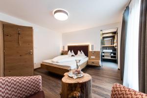 a bedroom with a bed and a table in a room at Alpenhof Lodge Alpin Superior in Saltusio +34 photos
