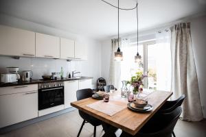 a kitchen with a wooden table and black chairs at Claudia's Seeherz in Wasserburg