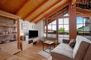 a living room with a couch and a tv at Landhaus Exklusive Appartement in Wiederhofen