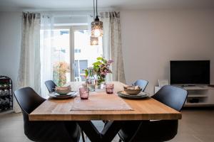 a dining room with a wooden table and chairs at Claudia's Seeherz in Wasserburg