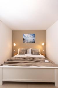 a bedroom with a large white bed with two pillows at Claudia's Seeherz in Wasserburg