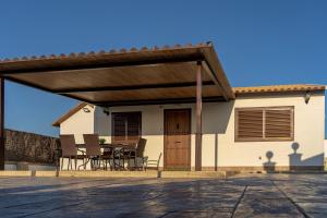awning over a house with a table and chairs at Casa Bellavistas in Vejer de la Frontera