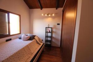 a small bedroom with a bed and a window at Casa Bellavistas in Vejer de la Frontera