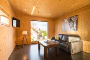 a living room with a leather couch and a table at Ferienwohnungen Winzerhof Keller in Auggen