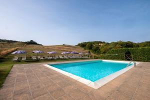 ein Swimmingpool mit Stühlen und Sonnenschirmen in einem Garten in der Unterkunft Edera in Arcidosso