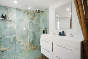 a bathroom with a white sink and a shower at Seaside Haven - Soulful Stays in Porto Moniz +12 photos