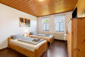 two beds in a room with two windows at Kastanienallee 43 in Ilsenburg