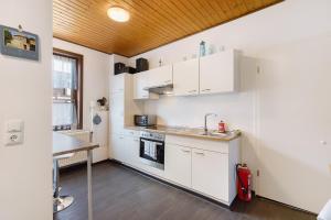 a kitchen with white cabinets and a wooden ceiling at Kastanienallee 43 in Ilsenburg