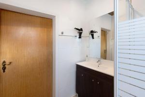 a bathroom with a sink and a wooden door at Kastanienallee 43 in Ilsenburg +30 photos
