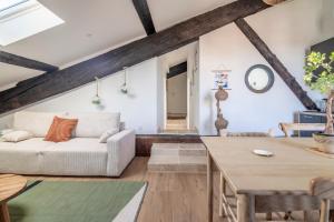 a living room with a couch and a table at Le Somail - Louis 14 in Ginestas
