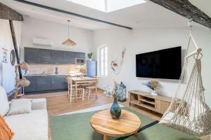 a living room with a couch and a table at Le Somail - Louis 14 in Ginestas