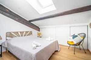 a bedroom with a bed and a chair at Le Somail - Louis 14 in Ginestas