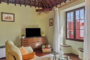 a living room with a couch and a tv at Casa Isabel in Santa Brígida