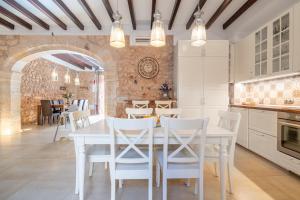 a kitchen and dining room with a white table and chairs at Cas Mercader in Algaida