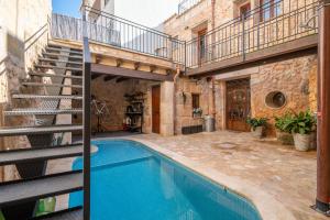 a house with a swimming pool and a staircase at Cas Mercader in Algaida