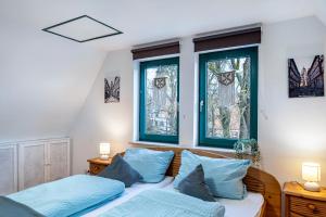 a bedroom with two beds and two windows at Ferienwohnung Altstadtblick in Alsfeld