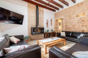 a living room with leather furniture and a fireplace at Cas Mercader in Algaida