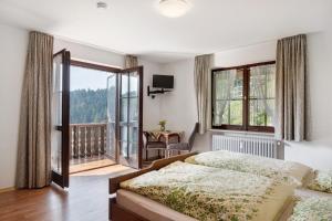 a bedroom with a bed and a balcony at Bergbauernhof 1910 in Oberharmersbach