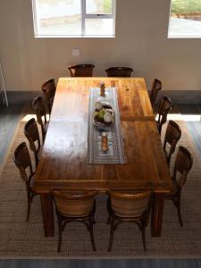 a wooden table with chairs and a bowl of fruit on it at Hemel Bushveld Lodge in Vaalwater