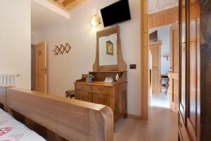 a bedroom with a mirror and a wooden dresser at Agritur Maso Pan in Caderzone Terme