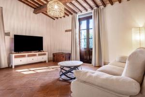 a living room with a tv and a couch and a table at Podere San Biagio in Capalbio