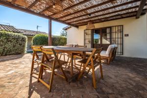 a wooden table and chairs on a patio at Podere San Biagio in Capalbio