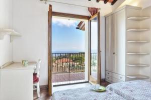 a bedroom with a door open to a balcony at Casa Consuelo App. 2 (trilocale) in Capoliveri