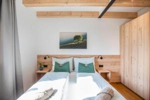 a bedroom with a large bed with green pillows at Meine Bleibe Apartment Olive in Appiano sulla Strada del Vino