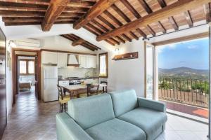 a living room with a couch and a kitchen at Casa Consuelo App. 2 (trilocale) in Capoliveri