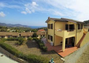 a large yellow house with a porch and stairs at Casa Consuelo App. 2 (trilocale) in Capoliveri +11 photos