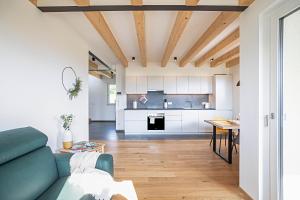a living room and kitchen with a blue couch at Meine Bleibe Apartment Olive in Appiano sulla Strada del Vino