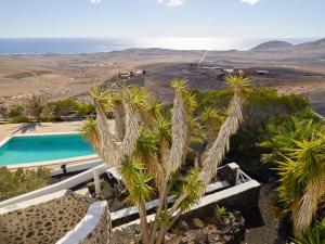 a villa with a swimming pool and palm trees at Finca La Calerita B in Uga