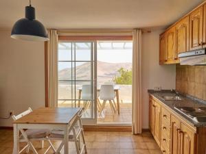 a kitchen with a table and a dining room with a view at Finca La Calerita B in Uga