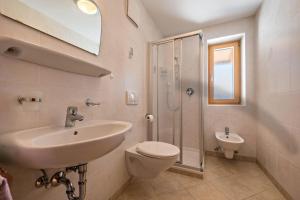 a bathroom with a sink and a toilet and a shower at Apartment Dolomitenblick in Mühlbach