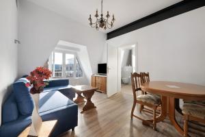 a living room with a blue couch and a table at Die Alter Schwede Wohnung 2 in Vechta
