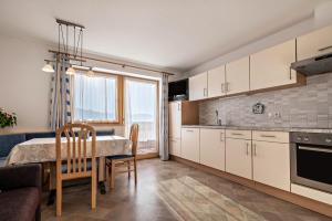 a kitchen with a table and a dining room at Apartment Dolomitenblick in Mühlbach +16 photos