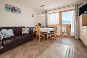 a living room with a couch and a table with chairs at Apartment Dolomitenblick in Mühlbach