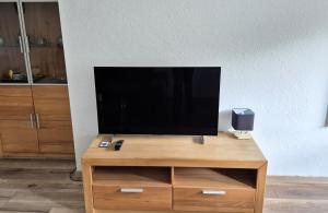 a flat screen tv sitting on top of a wooden entertainment center at Fritz - Moderne FeWo mit Garten für Urlaub & Work & LEGO in Giengen-Burgberg in Giengen an der Brenz