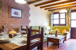 a living room with a table and a brick wall at Las Puentes 2 in Candelario