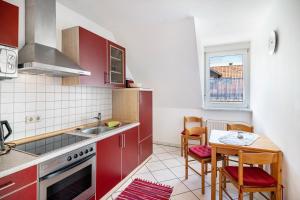 a kitchen with red cabinets and a table and a window at Ferienwohnungen Meyer in Hochbuch