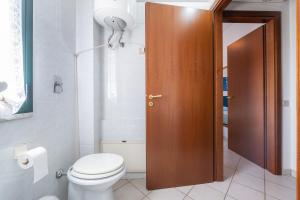 a bathroom with a toilet and a brown door at Casa Vacanza Casi 2 in Villasimius +15 photos