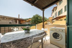 a patio with a table and a washing machine on a balcony at Casa Vacanza Casi 2 in Villasimius