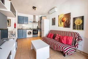 a living room with a couch and a kitchen at Apartamento Trilo 24 in Es Pujols
